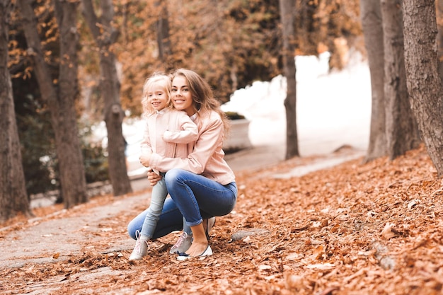 Lächelnde Mutter, die kleine Tochter im Park hält