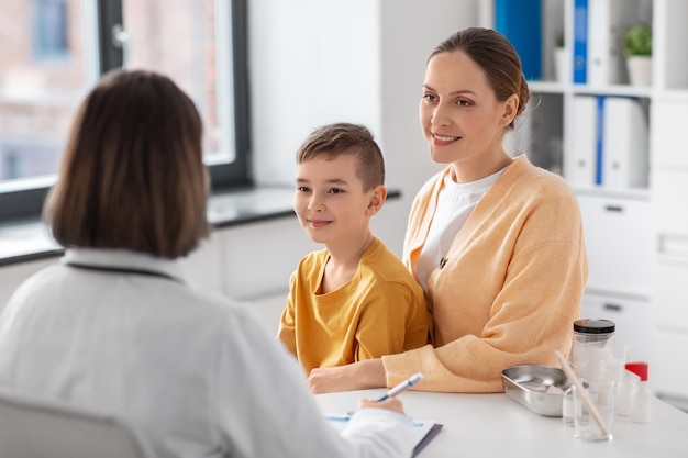 lächelnde Mutter, Sohn und Arzt sprechen in der Klinik