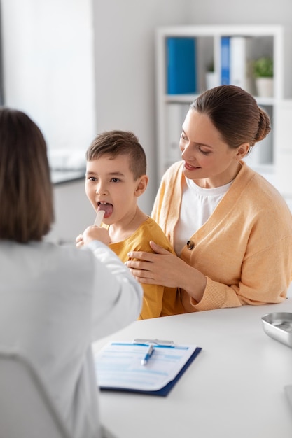 lächelnde Mutter, Sohn und Arzt sprechen in der Klinik