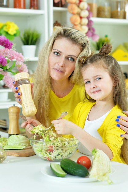 Lächelnde Mutter und Tochter, die zusammen kochen