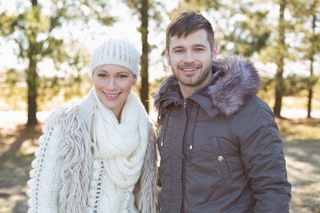 Lächelnde Paare in der Winterkleidung im Wald