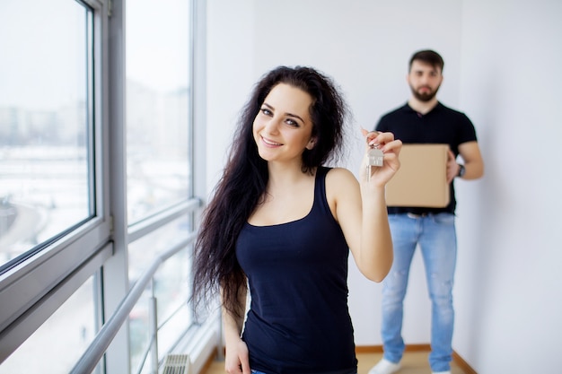 Lächelnde Paare packen Kästen im neuen Haus aus.