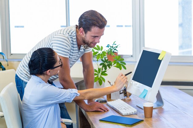 Lächelnde Partner, die zusammen an Computer arbeiten