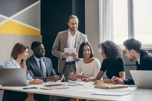 Lächelnde Planungsstrategie für das Geschäftsteam während der gemeinsamen Arbeit im modernen Büro
