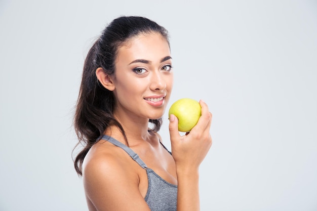 Lächelnde schöne Frau, die Apfel lokalisiert auf einer weißen Wand hält. Blick nach vorne