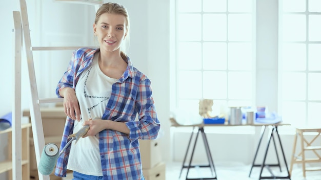 Lächelnde schöne Frau, die Innenwand des Hauses malt