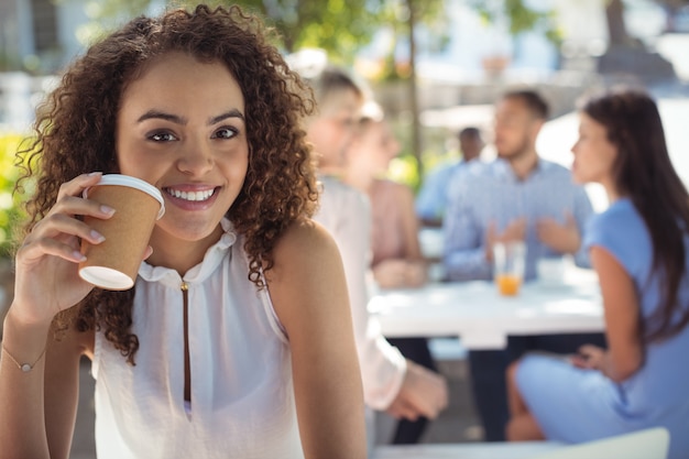 Lächelnde schöne Frau, die Kaffee im Restaurant trinkt