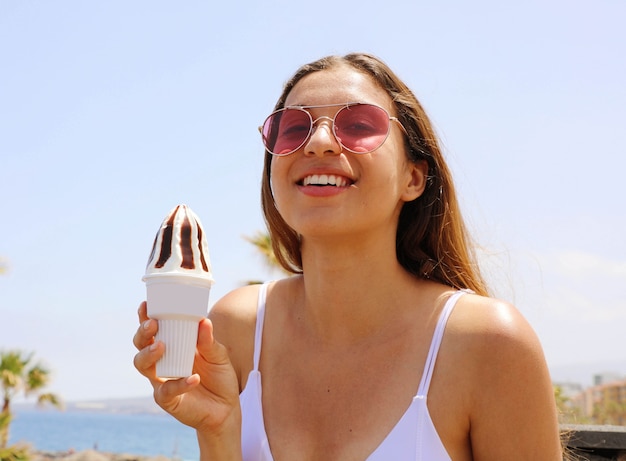 Lächelnde schöne Frau mit Sonnenbrille am Strand