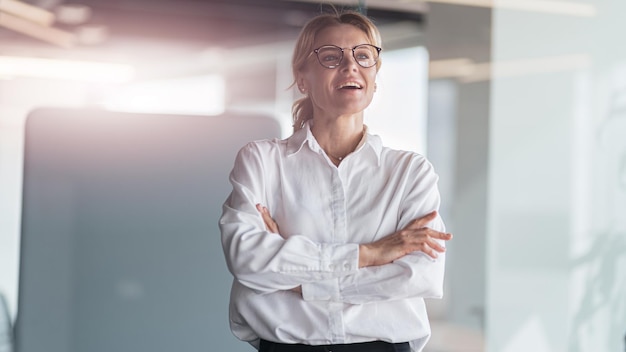 Lächelnde schöne Geschäftsfrau, die in einem modernen IT-Büro arbeitet und wegschaut