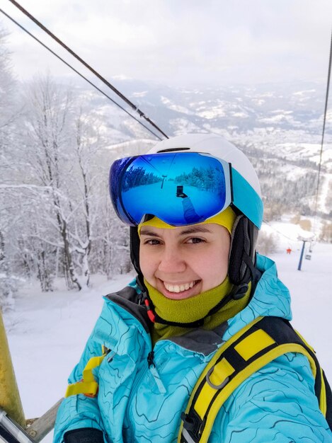 Lächelnde Skifahrerin macht Selfie-Foto Wintersaison