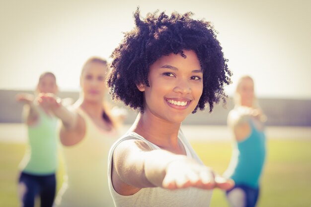 Lächelnde sportliche Frau, die Yoga in der Yogaklasse tut