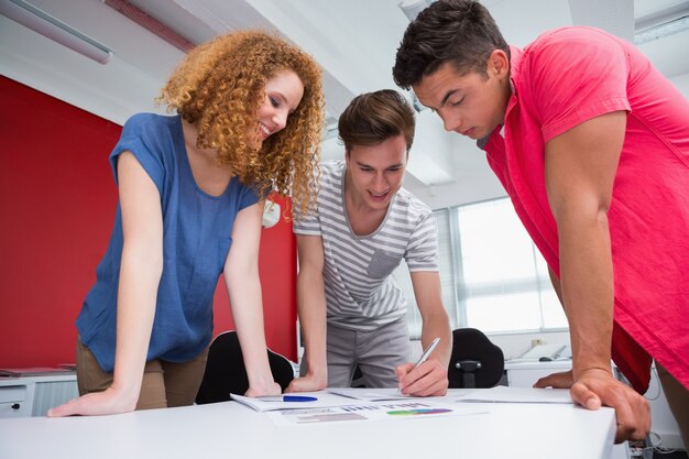 Lächelnde Studenten, die zusammen arbeiten und Kenntnisse nehmen