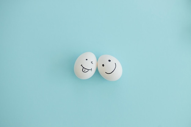 Lächelnde und traurige Eier auf blauem Hintergrund