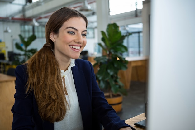 Lächelnde weibliche Führungskraft, die am Computer arbeitet