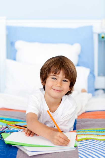 Lächelnde Zeichnung des kleinen Jungen im Bett