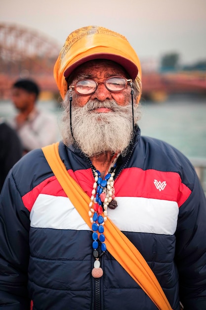 Foto lächelnder älterer mann mit bart posiert für die kamera in haridwar, indien