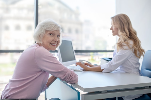 Lächelnder älterer Patient, der in der Arztpraxis sitzt