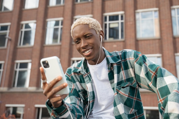 Foto lächelnder afroamerikanischer mann mit handy, der textnachricht liest, kommunikation online