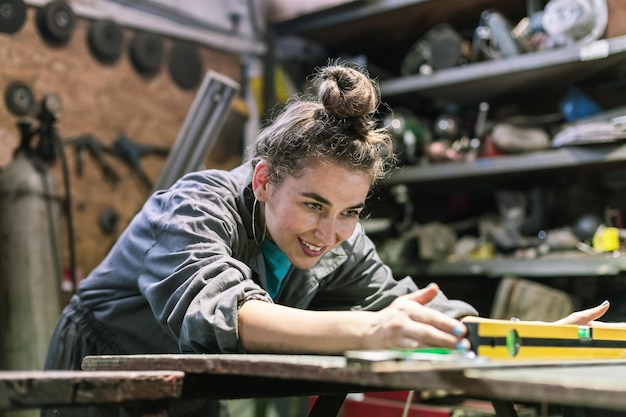 Foto lächelnder arbeiter, der in einer werkstatt arbeitet