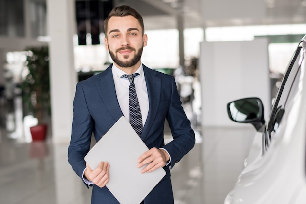 Lächelnder Autoverkäufer im Ausstellungsraum