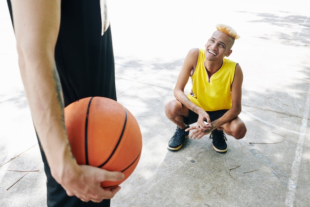 Lächelnder Basketballspieler, der seinen Teamkollegen ansieht