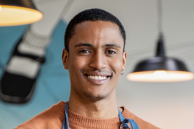 Foto lächelnder besitzer oder kellner in arbeitsuniform, der in einer modernen cafeteria oder restaurantkneipe steht konzept für die jobsuche arbeiten in der gastronomie