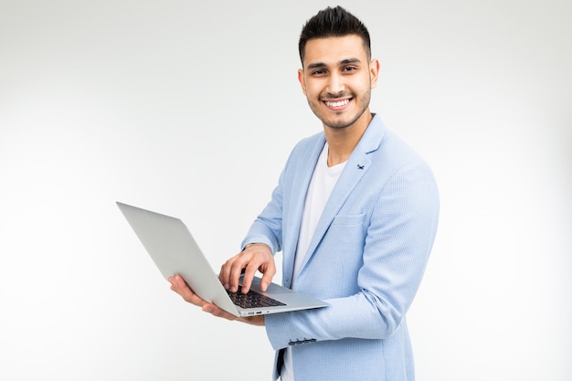 Lächelnder Büroangestelltermann mit einem offenen Laptop in seinen Händen auf einem weißen Studiohintergrund