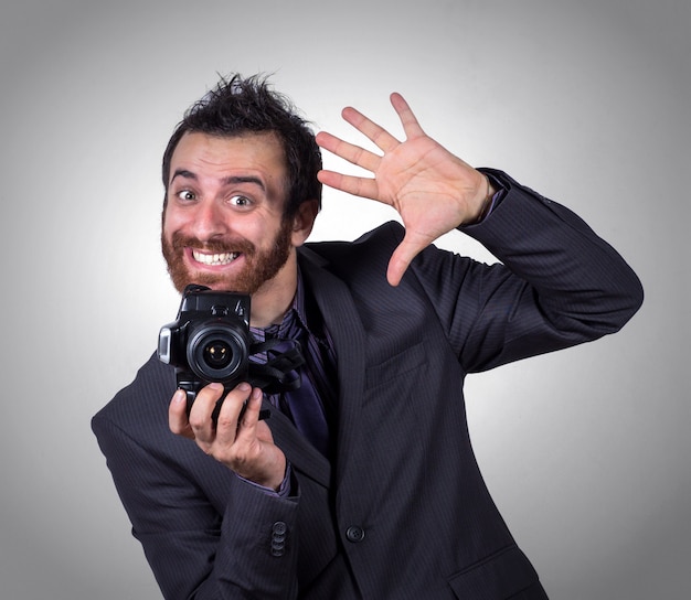 Lächelnder busnessman benutzt seine Berufskamera, um ein selfie zu machen