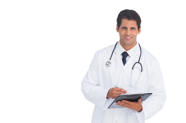 Lächelnder Doktor, der ein Klemmbrett und einen Stift hält
