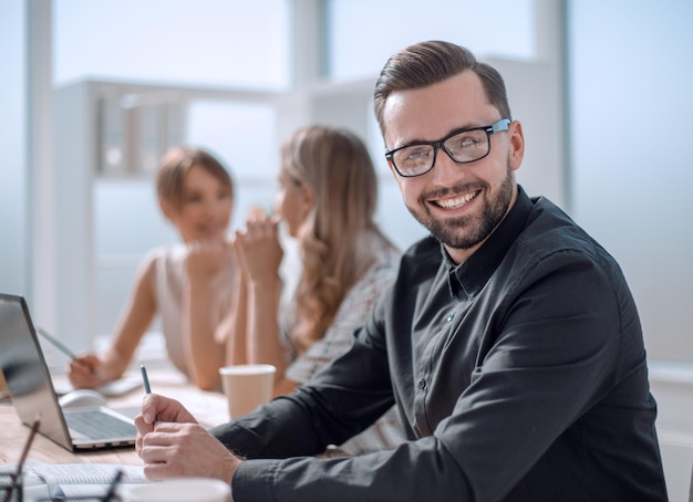 Lächelnder Geschäftsmann am Arbeitsplatz im Büro