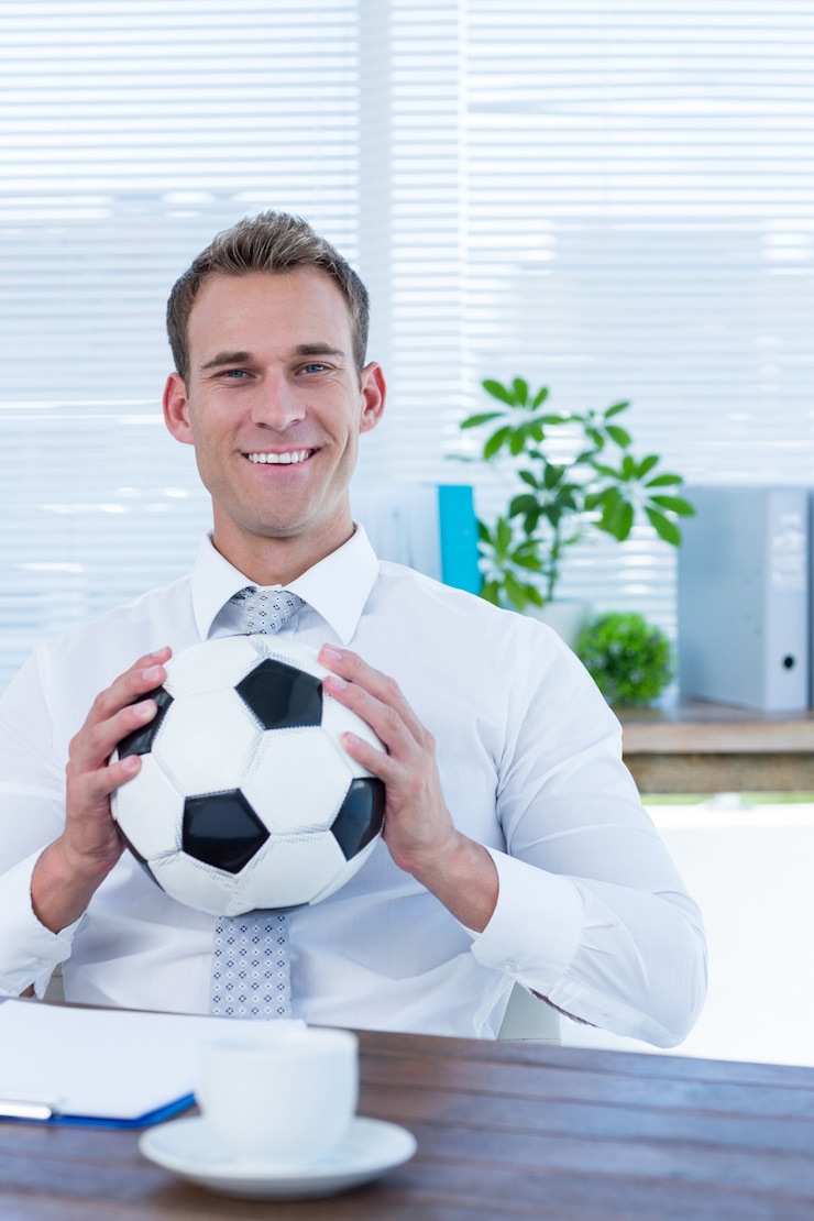 Foto lächelnder geschäftsmann, der einen fußball hält