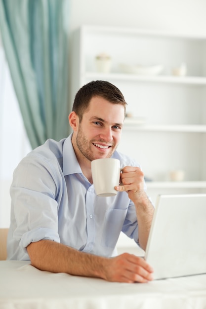 Lächelnder Geschäftsmann, der einen Tasse Kaffee hat