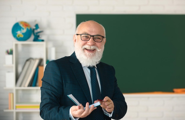 Lächelnder, glücklicher, reifer, eleganter Professor mit Brille Bildungs- und Wissenskonzept Lehrertag