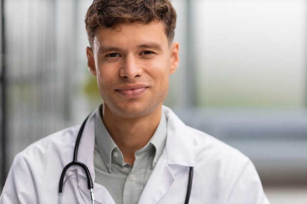 Foto lächelnder, gutaussehender männlicher arzt, der mit dem patienten vor der kamera spricht