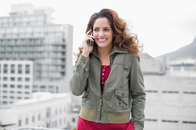 Lächelnder herrlicher Brunette beim Wintermodeanrufen