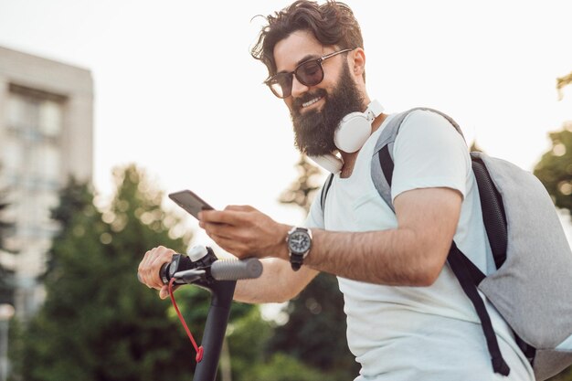 Lächelnder Hipster mit modernen Gadgets im Alltag