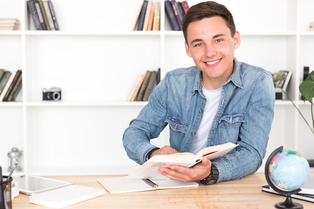 Lächelnder Jugendlicher, der im Klassenzimmer studiert