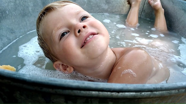 Lächelnder Junge in der Badewanne mit Schaum