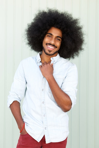 Lächelnder junger Afroamerikanermann mit Afro