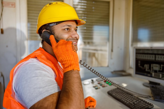 Lächelnder junger Baufachmann, der im Werk arbeitet