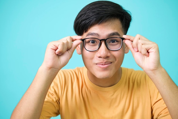 Lächelnder junger Mann mit Brille blickt vor isoliertem Hintergrund in die Kamera