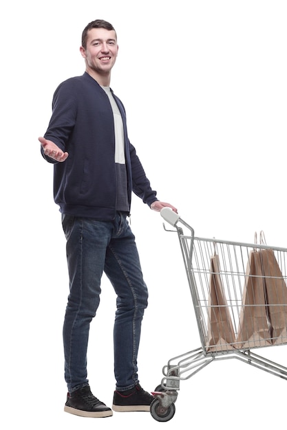 Lächelnder junger Mann mit einem Einkaufswagen