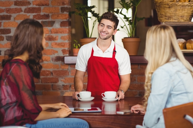 Lächelnder Kellner, der Kaffee zu den Kunden dient