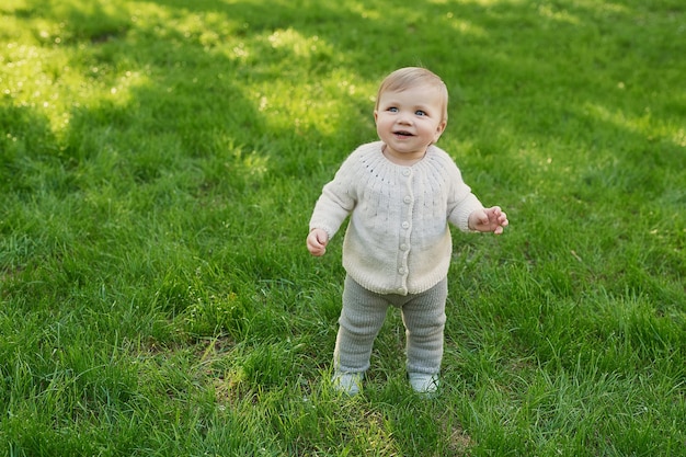 Lächelnder kleiner Junge auf Gras im Park Kinderschutztag Weltkindertag
