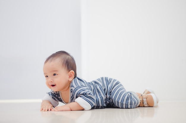 Lächelnder kriechender asiatischer Junge zu Hause