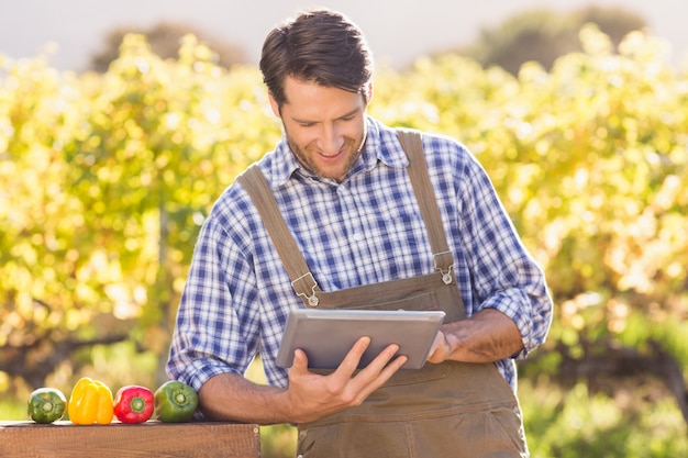 Lächelnder Landwirt, der eine digitale Tablette verwendet