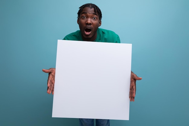 Lächelnder lustiger afrikanischer junger Mann hält Plakatwand mit Attrappe