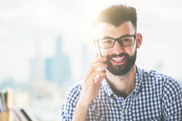 Lächelnder Mann, der am Telefon spricht