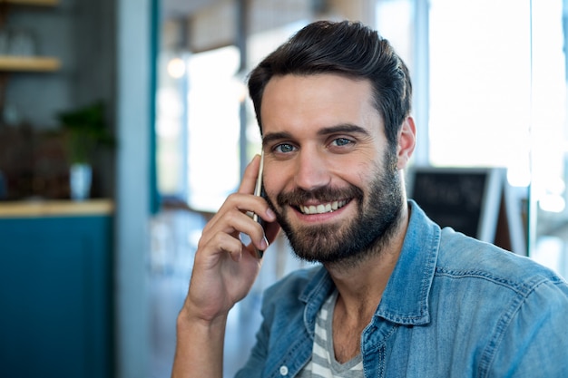 Lächelnder Mann, der auf Handy spricht