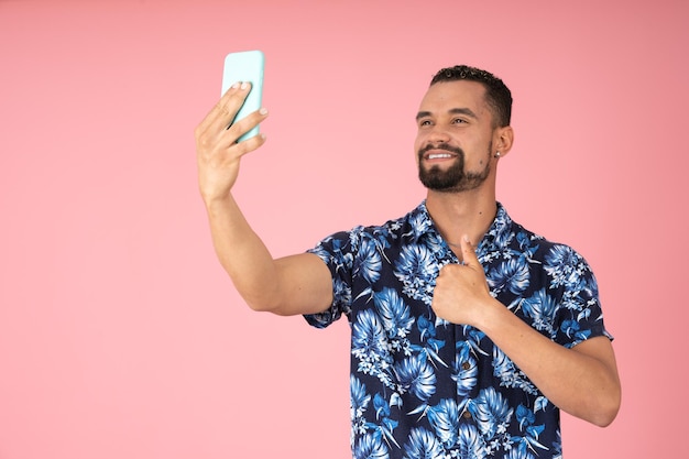 Lächelnder Mann, der ein Selfie mit erhobenen Daumen macht